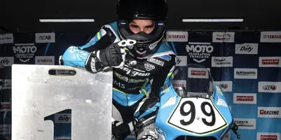 Remy Sanjuan sur sa moto n°99 derrière le panneau de la 1re place